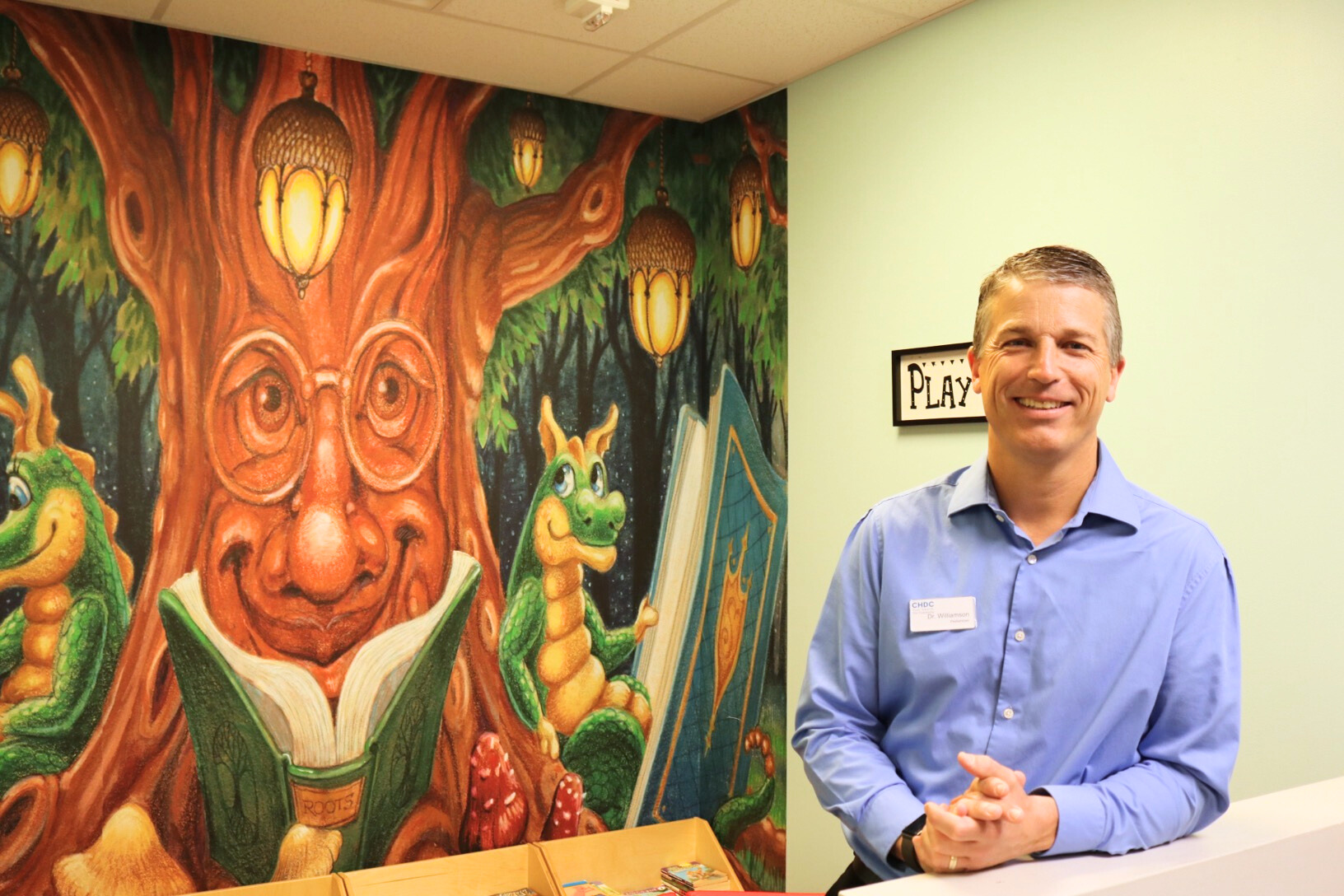 Pediatrics provider Dr. Williamson posing for a photo in the decorated waiting area.