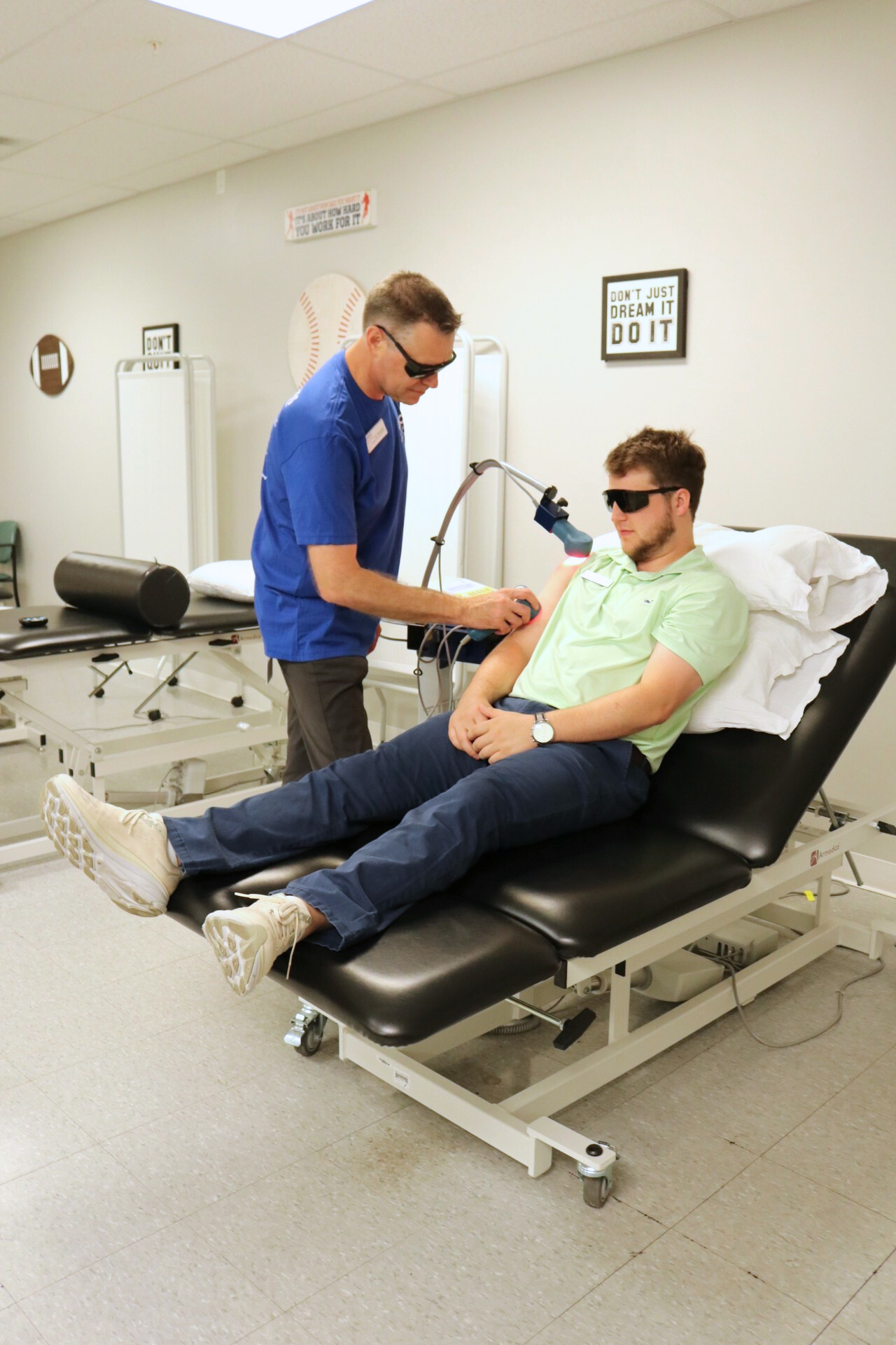 Physical Therapy provider using laser therapy on a patient.