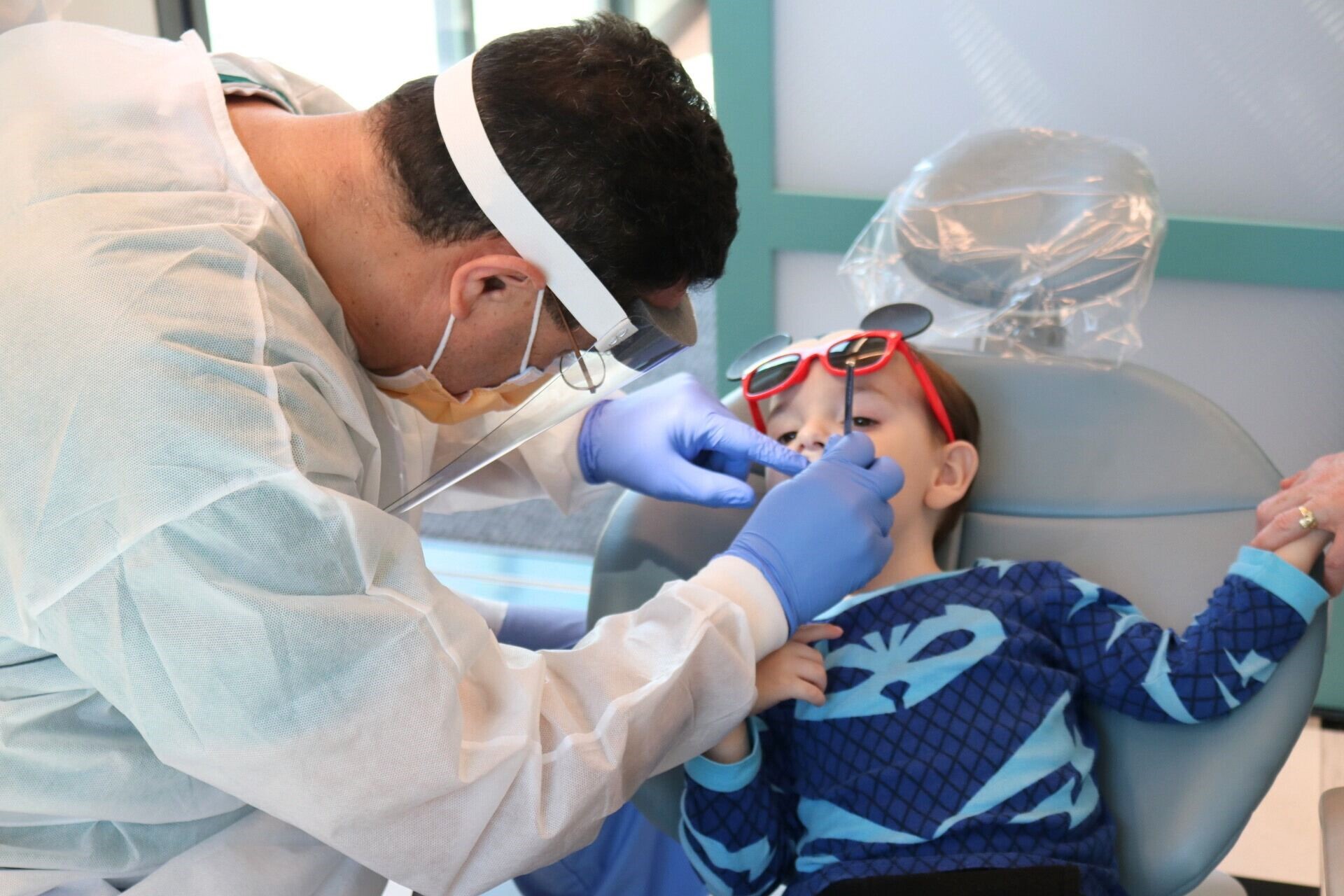 Dental provider cleaning the teeth of a pediatric patient