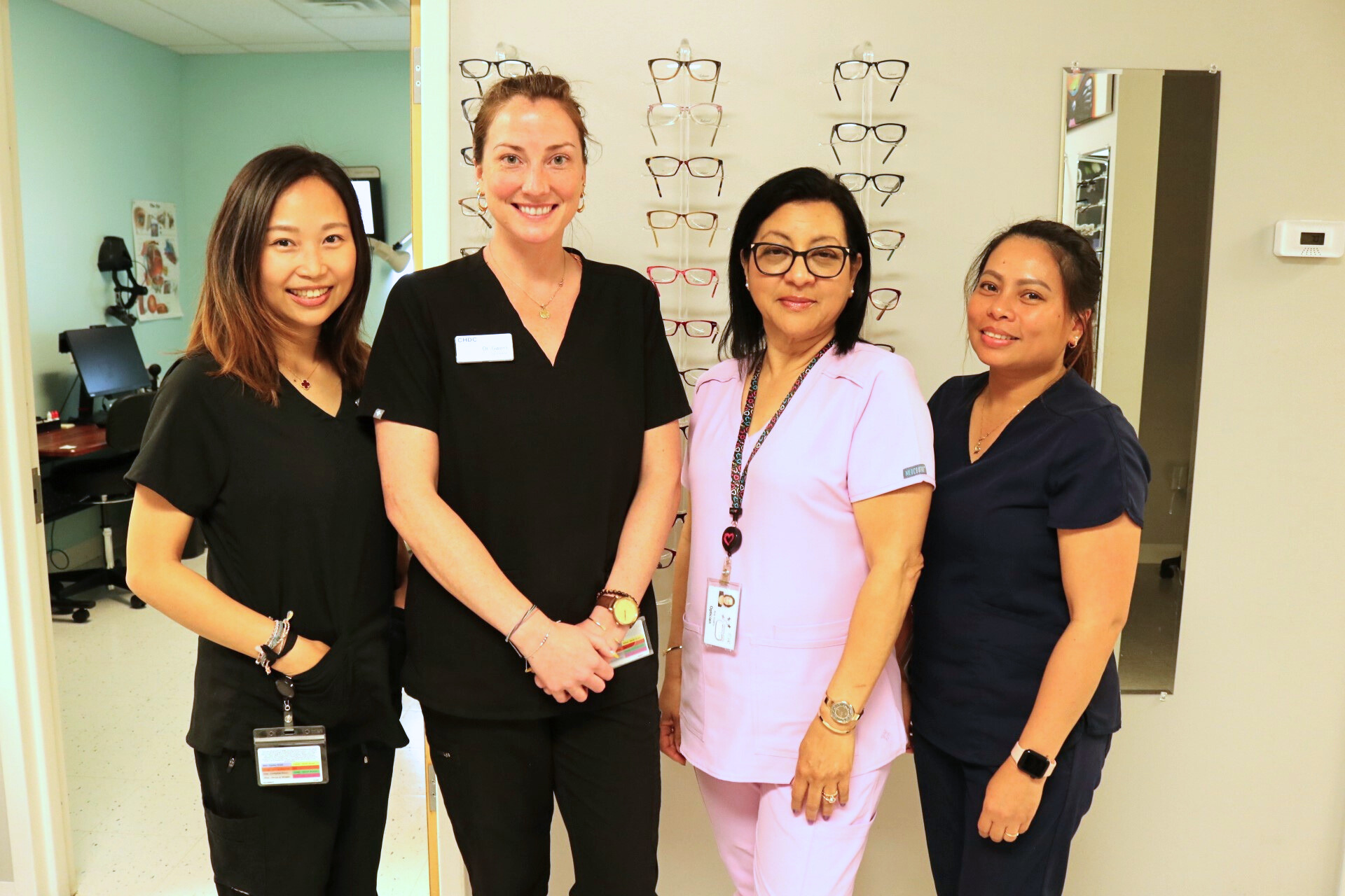 Vision care team of doctors and assistants smiling and posing for a photo.