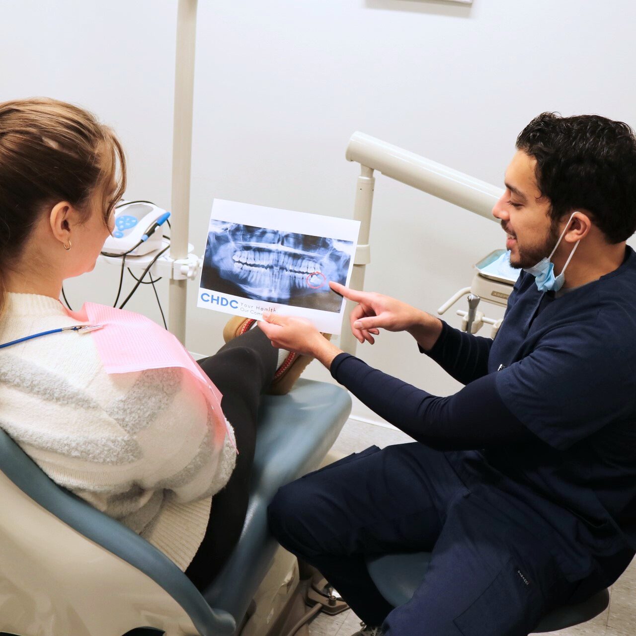 Dental provider showing a patient their x-rays and explaining what they see.